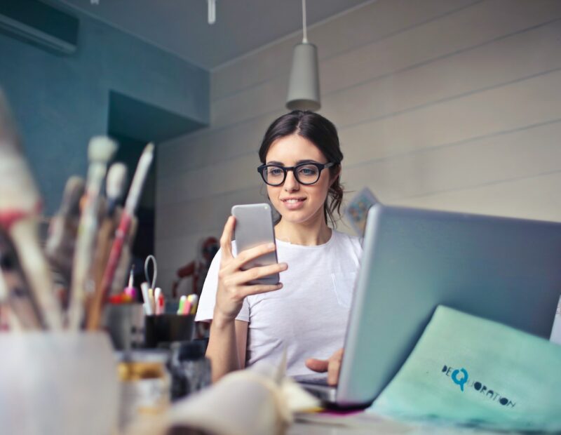 woman in white shirt using smartphone